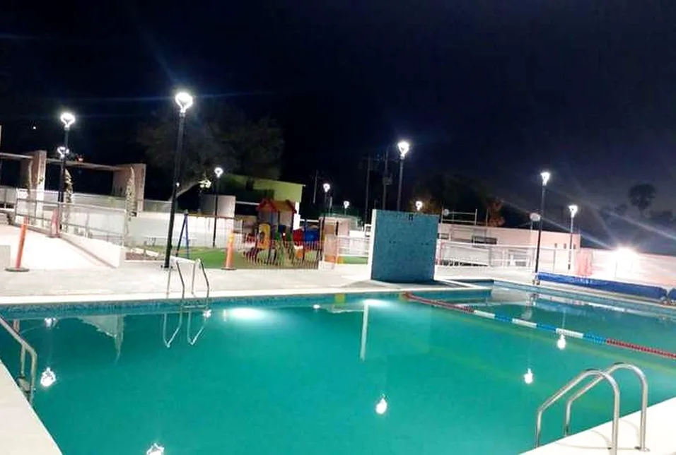 Alberca iluminada en el área recreativa de Cedros